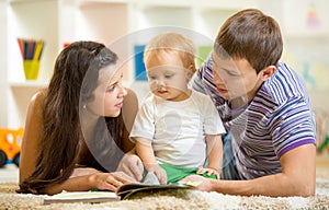 Young happy family with baby son reading children