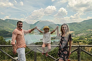 Young happy family on a background of a mountain lake Lago del Turano photo