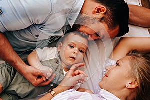 Young happy family. Careful young caucasian parents playing with their little cute baby boy.