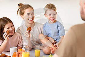 Young happy family eating morning breakfast together at home