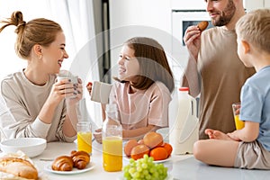 Young happy family eating morning breakfast together at home