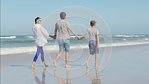 Young happy family enjoy vacation on beach ocean. Dad, mom and kid relax walking together near ocean.