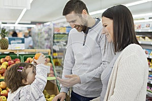 Young three-member family buying groceries in the supermarket