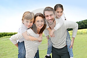 Young happy family of four outdoors