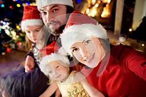 Young happy family of four taking a photo of themselves on Christmas