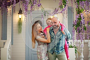 Young happy family having fun in courtyard of the summer house