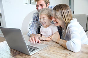 Young happy family on laptop at home