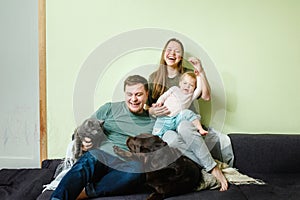 Young happy family with little toddler kid and pets dog and cat at home on the couch