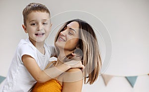 Young happy family loving mother and her child son having fun together at home, playing and laughing