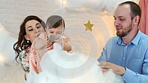 Young happy family playing with a baby having fun in the living-room