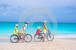 Young happy family riding bicycles duting beach