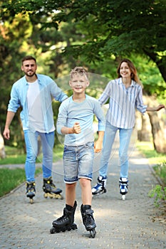 Young happy family roller skating in  park