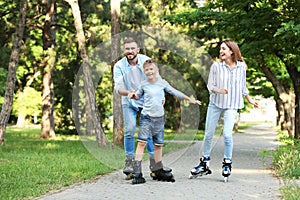 Young happy family roller skating in park
