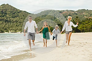 young happy family running by beach