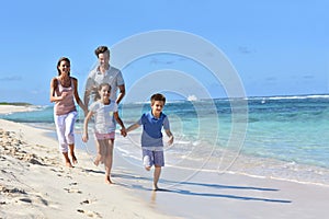 Young happy family running on the beach having fun