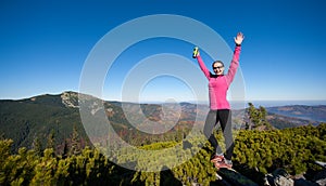 Young happy female hiker at the mountain top