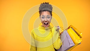 Young happy female holding colorful shopping bags, sale surprise, consumerism