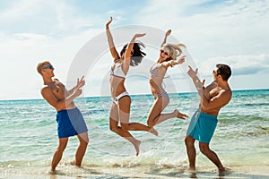 Young happy friends havin fun on the beach