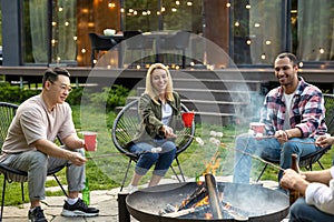 Young happy friends having picnic having fun and celebrating while grilling at barbecue party