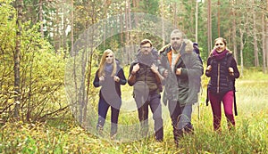 Young happy friends walking in forest and enjoying a good autumn