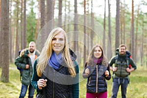 Young happy friends walking in forest and enjoying a good autumn