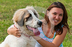 Young happy girl hugging her dog