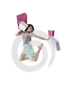 Young happy girl jumping with her shopping parcels