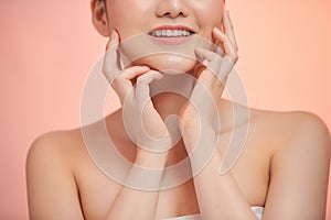 Young and happy girl with light make-up and closed eyes touching her chin and smiling