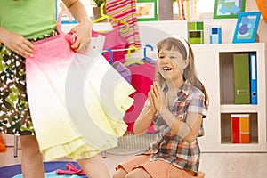 Young happy girl looking at colorful skirt