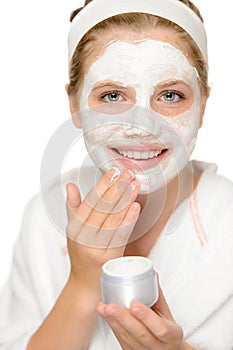 Young happy girl putting facial mask cleaning