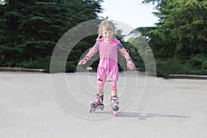 Young happy girl riding roller blades