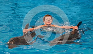 Young happy girl swimming with dolphin