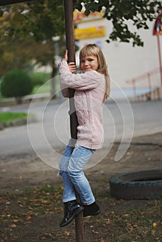 Young happy girl swinging on the crossbar