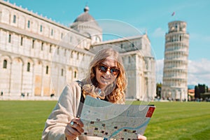 Young happy girl with toristic map on travel to Pisa. Tourist traveling visiting The Leaning Tower of Pisa.