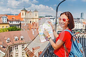 Dívka cestovatelka se dívá na mapu a snaží se najít správný směr pro další atrakci v evropském městě