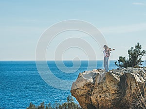 Young happy girl traveler standing on rock over sea, Turkey