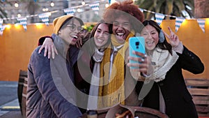 Young happy group of teenage friends taking a selfie portrait on winter day