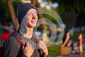 A young happy guy with problem skin having fun while walking around the summer city.