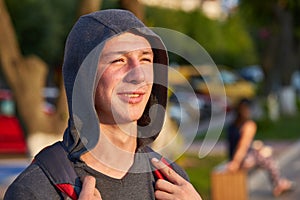 A young happy guy with problem skin having fun while walking around the summer city.