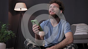 Young happy guy with smartphone, read news from phone. High-quality video post. High quality 4k footage