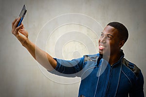Young happy handsome African man taking selfie