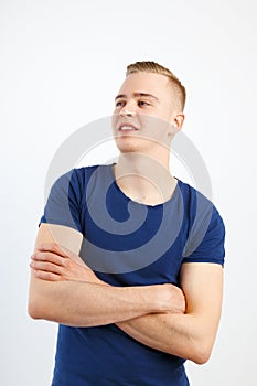 Young happy handsome man in blue shirt and jeans poses