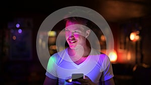 Young Happy Handsome Man Thinking While Using Phone In The Club