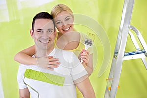 Young happy handy couple painting new house