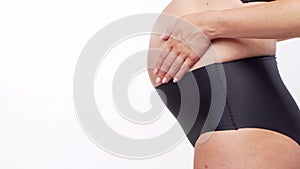 Young, happy and healthy pregnant woman in front of white background. Studio video. Baby expectation, pregnancy and