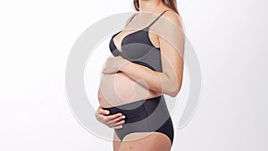 Young, happy and healthy pregnant woman in front of white background. Studio video. Baby expectation, pregnancy and