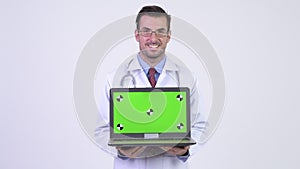 Young happy Hispanic man doctor showing laptop