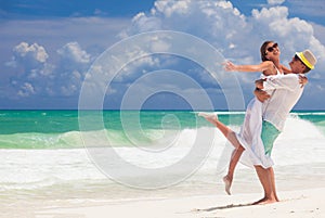 Young happy honeymoon couple in white clothes on seashore