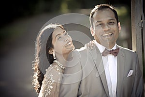 Young happy Indian couple laughing outdoors in sunshine