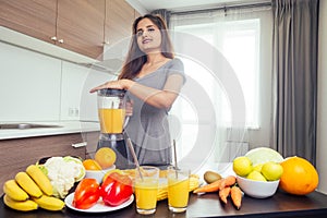 Young happy indian woman making healthy drinks on juicer smoothie jar in modern home